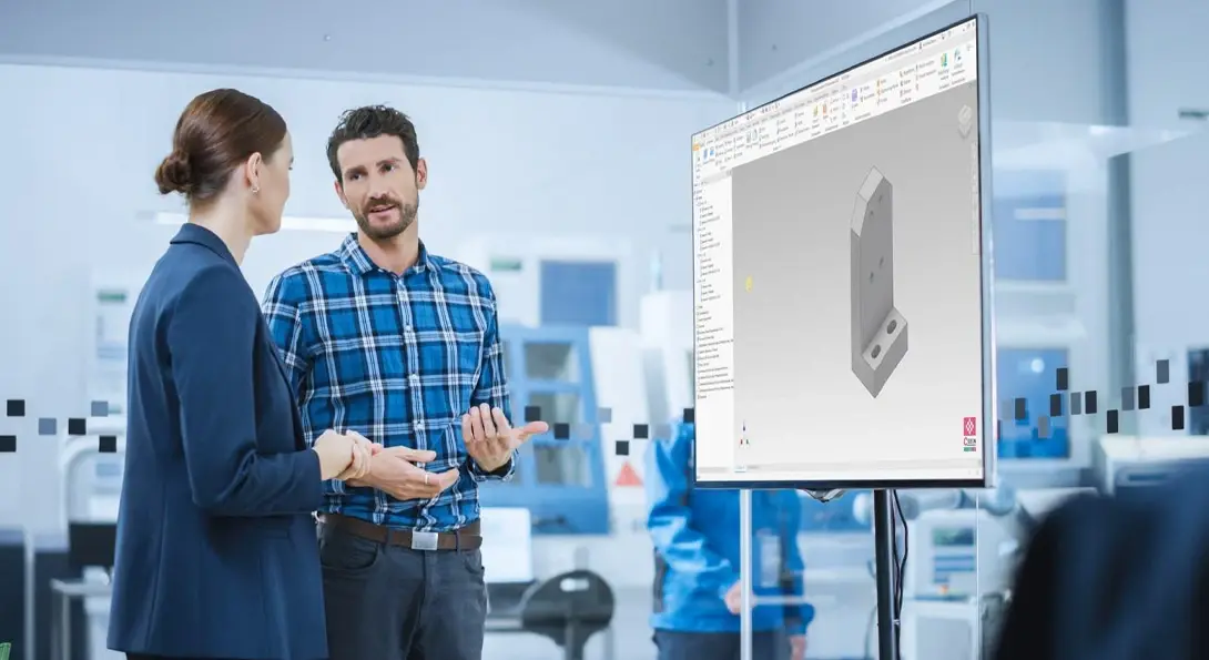 2 Personen sprechen über CAD-Automatisierung vor einer Leinwand mit einem Bauteil